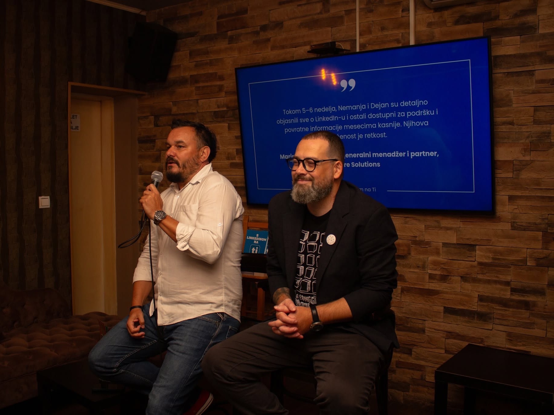 Dejan Pataki speaking into a microphone and Nemanja Živković listening beside him at a Compound Live session